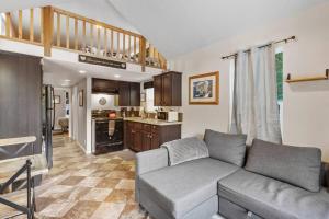 uma sala de estar com um sofá e uma cozinha em Cozy Tiny Home Steps Away From Mt. Rainier em Ashford