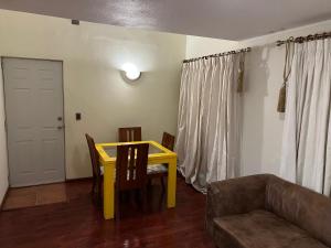 - un salon avec une table jaune et un canapé dans l'établissement Apart hotel Chillan - Full house - Ohiggins - Empresas- Factura - Parking, à Chillán