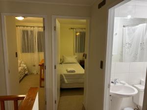 1 dormitorio con 1 cama y baño con lavabo. en Apart hotel Chillan - Full house - Ohiggins - Empresas- Factura - Parking en Chillán