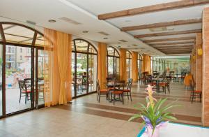 サニービーチにあるRoyal Sun Apartmentsのテーブルと椅子と窓のあるレストラン