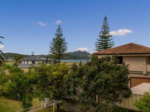 a group of trees in front of a house at Hosts on the Coast Views to Mercury in Whitianga