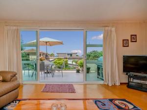 a living room with a large sliding glass door at Hosts on the Coast Views to Mercury in Whitianga