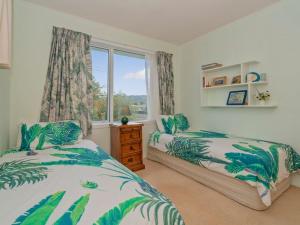 a bedroom with two beds and a window at Hosts on the Coast Views to Mercury in Whitianga