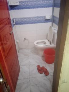 a bathroom with a toilet and a pair of slippers at Hotel Bonolota international in Rājshāhi
