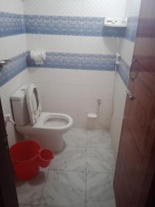 a small bathroom with a toilet and a bucket at Hotel Bonolota international in Rājshāhi