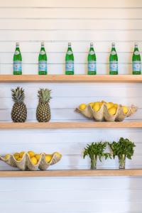 a set of shelves with bottles of water and pineapples at The Clovelly Hotel in Sydney