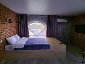 Un dormitorio con una cama grande con ventana. en Апарт-отель Attic, en Zabaykal'sk