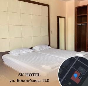 una camera da letto con un grande letto con un tablet sopra di SK Hotel a Bishkek