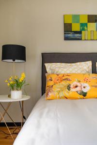 a bed with a yellow pillow and a table with a lamp at Domaine de la Serve in Lancié