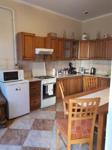 a kitchen with wooden cabinets and white appliances at Edina Apartman in Sátoraljaújhely