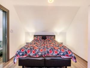 1 dormitorio con 1 cama con colcha de flores en Restful Holiday home in Herselt with Garden, en Herselt
