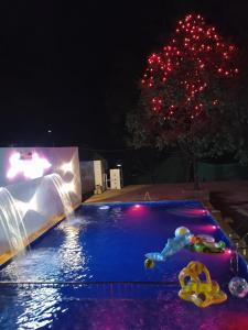 una piscina por la noche con juguetes en el agua en Sayeban Hotel en Mātherān