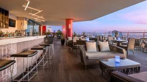 a restaurant with a bar with chairs and tables at Seda Residences Makati in Manila