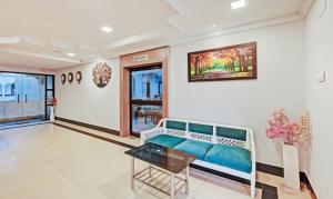 een woonkamer met een bank en een schilderij aan de muur bij Treebo Trend Sidhartha International Baliapanda in Puri