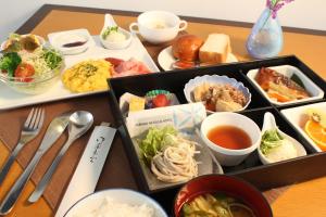 a table with a tray of different types of food at Furano Natulux Hotel in Furano