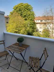 a balcony with two chairs and a table and a plant at Perfect apartment to visit the fair or city in Düsseldorf