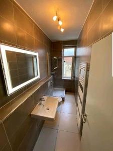 a bathroom with a sink and a toilet and a window at Perfect apartment to visit the fair or city in Düsseldorf