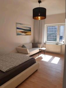 a bedroom with a bed and a couch at Perfect apartment to visit the fair or city in Düsseldorf