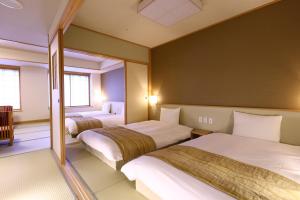 a hotel room with two beds and a mirror at Oyado Tsukiyo no Usagi in Izumo