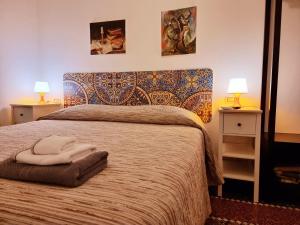 - une chambre dotée d'un lit avec 2 lampes et des serviettes dans l'établissement Affittacamere House LeoMar di Sara, à Gênes