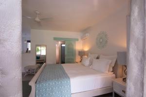 a bedroom with a large white bed and a chair at Le Mandala Moris in Pointe aux Canonniers