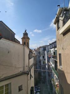 uma vista para um beco entre edifícios com uma torre de relógio em Costa e Mare em Savona