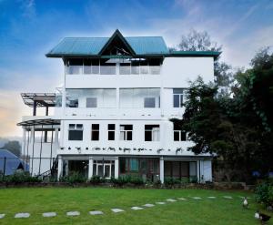 a large white building with a green roof at Tea Mount Forest in Nuwara Eliya