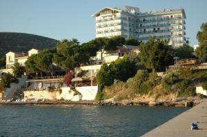 a building on a hill next to a body of water at Arora Hotel in Kusadası