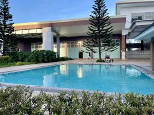 a large blue swimming pool in front of a building at Cozy @ Cool in Tagaytay