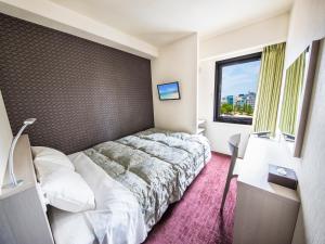 a hotel room with a bed and a window at Reisenkaku Hotel Kawabata in Fukuoka