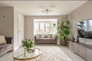 a living room with a couch and a glass table at Virginia Water Family getaway in Virginia Water