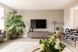 a living room with a flat screen tv on a wall at Virginia Water Family getaway in Virginia Water +34 photos
