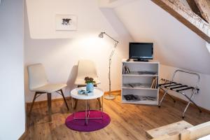 a living room with two chairs and a table and a tv at Netts Landhaus in Neustadt an der Weinstraße