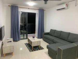 4A Icon Residence في كوالا ترغكانو: غرفة معيشة مع أريكة وتلفزيون