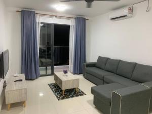 a living room with a couch and a tv at 4A Icon Residence in Kuala Terengganu