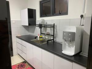 a kitchen counter with a sink and a microwave at 4A Icon Residence in Kuala Terengganu