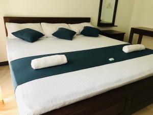 łóżko z 2 poduszkami i 2 ręcznikami w obiekcie Miyonra - Anuradhapura w mieście Anuradhapura