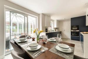 a kitchen and dining room with a table and chairs at Virginia Water Family getaway in Virginia Water