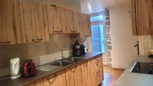 a kitchen with wooden cabinets and a sink and a window at Les Maisons de Concasty in Boisset