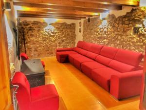 a living room with a red couch and chairs at Masía Can Janet in Arbúcies