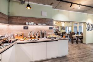 a restaurant with a counter with food on it at Hotel am Markt in Eisenach