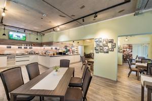 a restaurant with tables and chairs and a kitchen at Hotel am Markt in Eisenach +23 photos