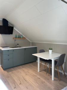 a kitchen with a table and chairs and a sink at Modern, small appartment in Larvik