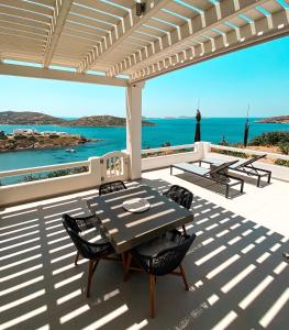 una mesa y sillas en un patio con vistas al océano en Nautilus Apartments en Lipsoí