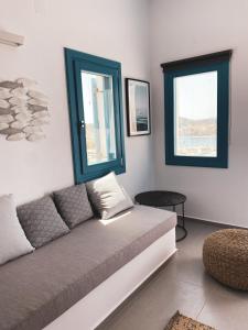 a living room with a couch and two windows at Nautilus Apartments in Lipsoi