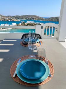 une table avec une plaque bleue et un verre de vin dans l'établissement Nautilus Apartments, à Lipsi