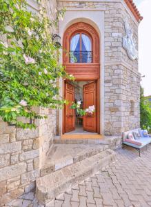 una casa in mattoni con una porta in legno e una panca di Kose Konak Butik Hotel-Special ad Alaçatı