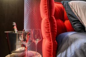 dos copas de vino sentadas en una mesa junto a un sofá en Villa avec jacuzzi privatif en Saint-Cyr-lʼÉcole