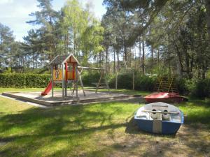 a playground with a slide and a boat on the grass at Lenzer Parkblick am Plauer See in Lenz