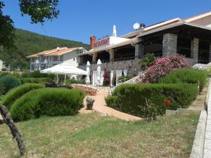 ein Gebäude mit einem Garten davor in der Unterkunft Hotel Zlatni Lav in Martinšćica